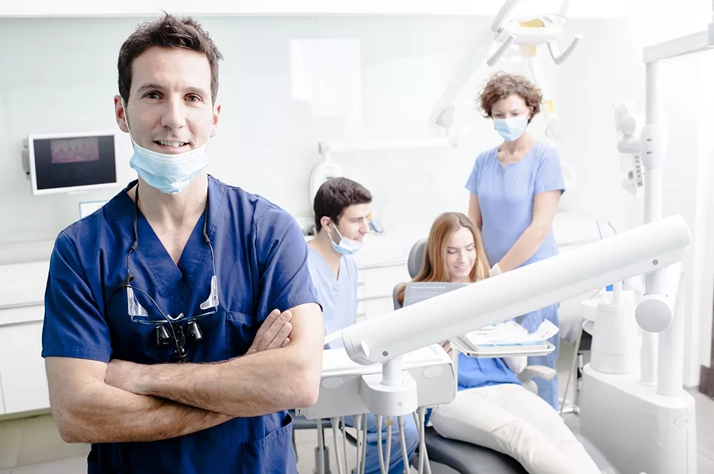 Dentist and staff near patient